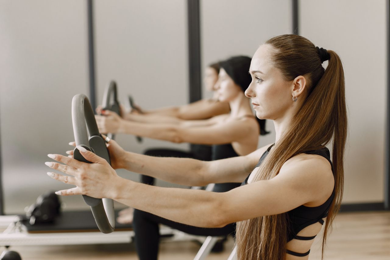 Women performing pilates exercises with magic rings, focusing on fitness and healthy lifestyle.